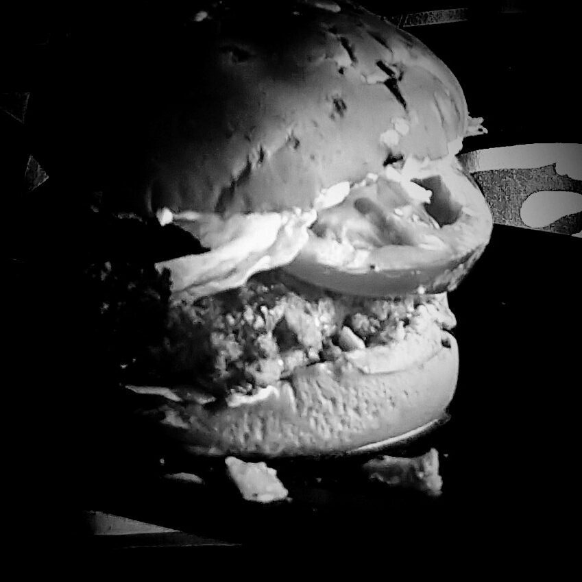 Black and white photo of homemade cheeseburger.