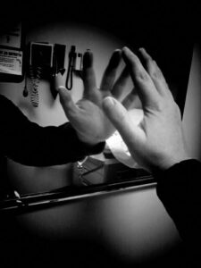 Black and white photo of reflection of arm in hospital mirror.