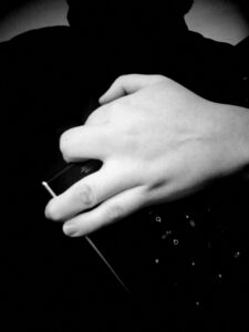 Black and white photo of hand holding keyboard.