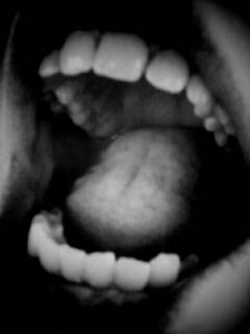 Black and white photo of open human mouth.