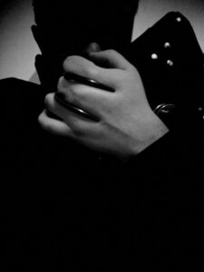 Black and white photo/self portrait with claw rings.