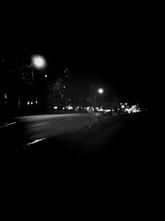 Black and white photo of traffic in the city at night.