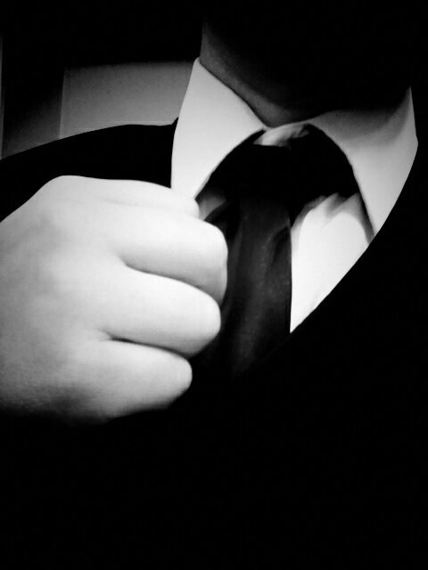 Black and white photo/self portrait of my hand adjusting suit jacket.