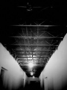 Black and white photo of hallway in warehouse.