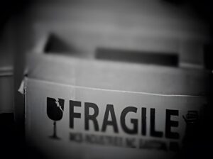 Black and white photo of cardboard box with the word FRAGILE on the side.