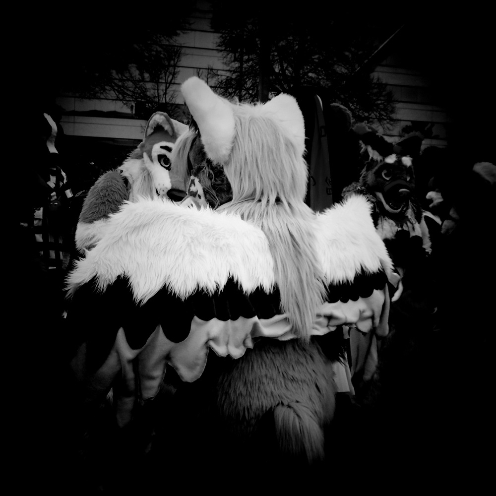 Black and white photo of fursuiters at con.