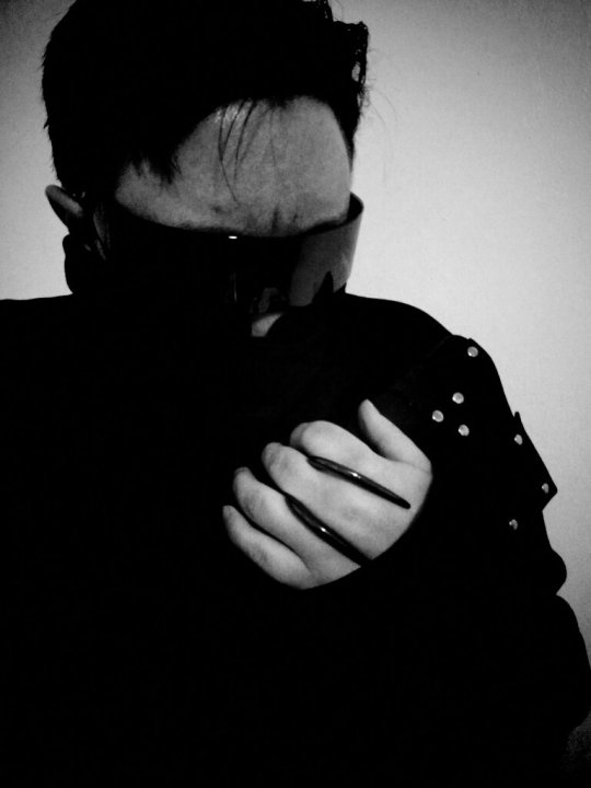 Black and white photo/self portrait wearing futuristic shades, face cowl, jacket, and two Gareth Pugh style claw rings.