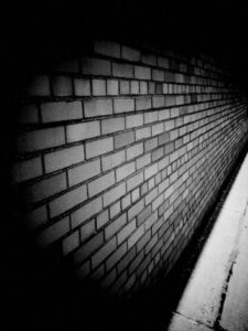 Black and white photo of brickwork on the side of building.