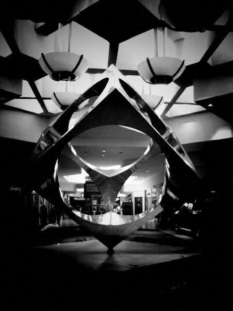 Black and white photo of art in a mall/shopping center.