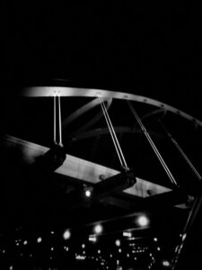 Black and white photo of bridge at night.