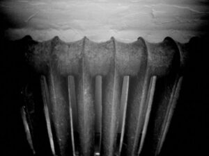 Black and white photo of heating radiator in warehouse.