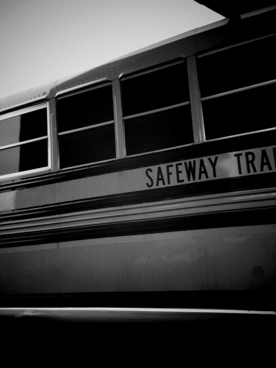 Black and white photo of side of school bus.