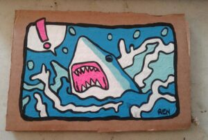 Finished painting of Derp Shark on cardboard. Cartoon looking shark with exclamation in a word bubble painted on cardboard.