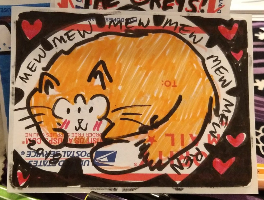 Marker drawing of a cat with three eyes curled up with it's tail on a sticker surrounded by hearts.