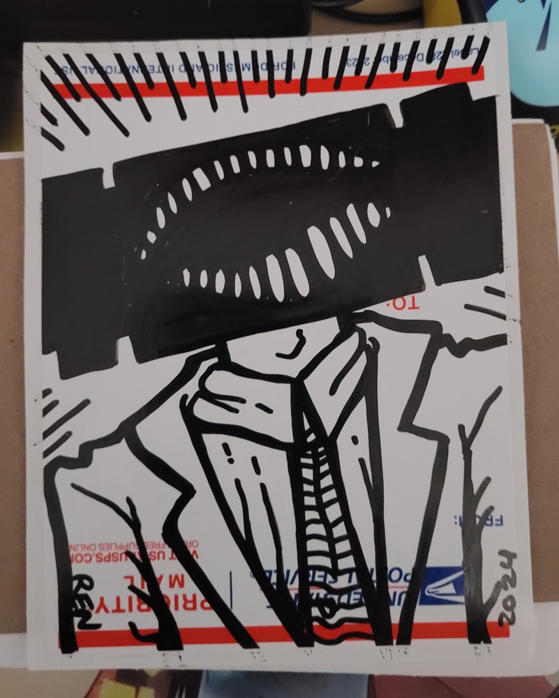 Photo of drawing on sticker of a block headed creature with a big open mouth wearing a suit.