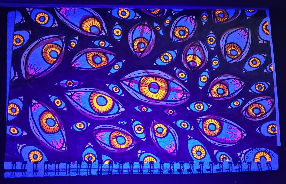 Photo of drawing marker art under black light depicting a eyes, many eyes. Title "The Look Like Other People" 