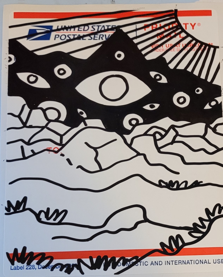 Photo of marker art on sticker. Art depicts a black mountain with eyes of varying sizes inside, then rocky terrain in front of it. The sun is off to the right, shining it's rays. This is the work in progress photo.